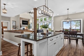Una cocina moderna con una isla central, suelo de madera y un comedor con vistas.