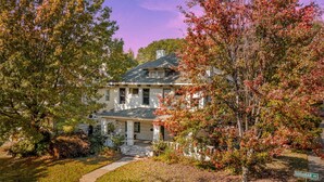 A two-story house with a front porch, a driveway, and a street sign for Goodbar Ave. - 6BR Home Private Pool Spa Games Gazebo (Memphis)
