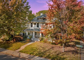 A two-story house with a front porch, a driveway, and a street sign for Goodbar Ave. - 6BR Home Private Pool Spa Games Gazebo (Memphis)