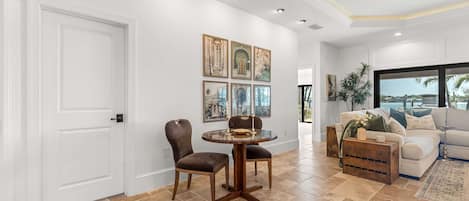 A spacious living room with a dining area, a large window with a view, and a cozy seating arrangement.