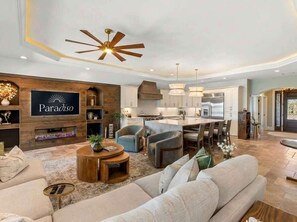 Ein modernes Wohnzimmer mit einer Couch, einem Couchtisch und einem Fernseher, der 'Paradiso' zeigt.