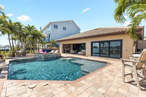 Ein Pool mit Whirlpool, Liegestühlen und einer überdachten Terrassenbereiches.