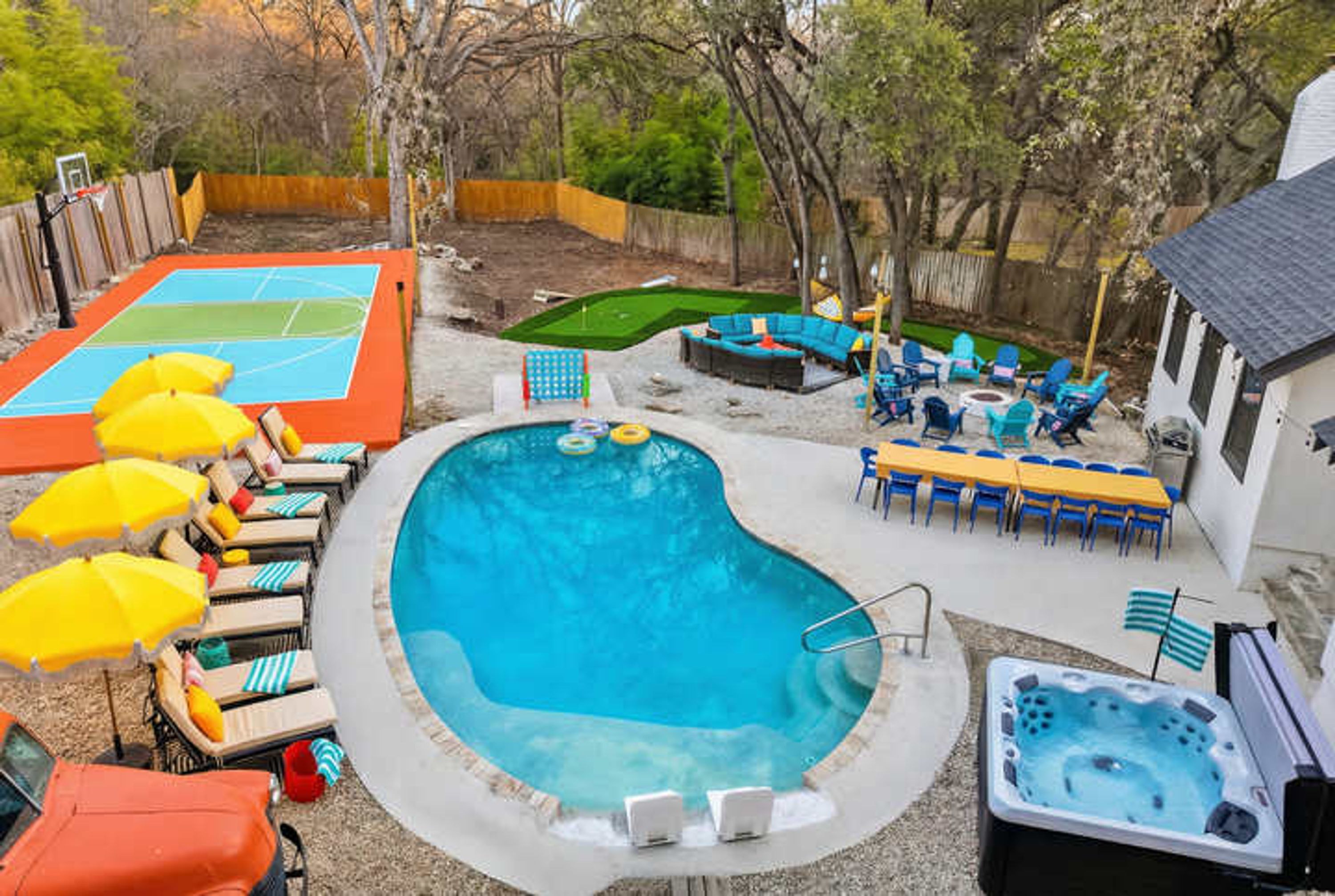 A backyard with a swimming pool, hot tub, and outdoor seating area.