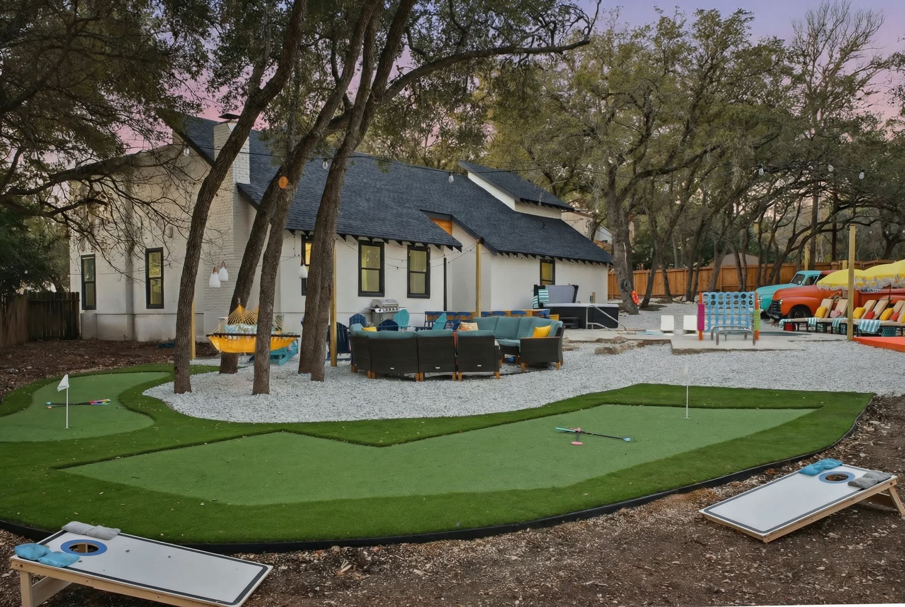 A backyard with artificial turf, a pool table, and a play area with a slide.