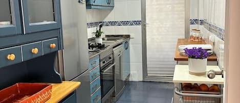 A kitchen with blue cabinets, a stove, and a sink.