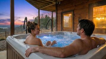 Una cabaña de madera con jacuzzi y vistas al paisaje.
