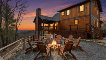 A wooden cabin with a fire pit and outdoor seating.