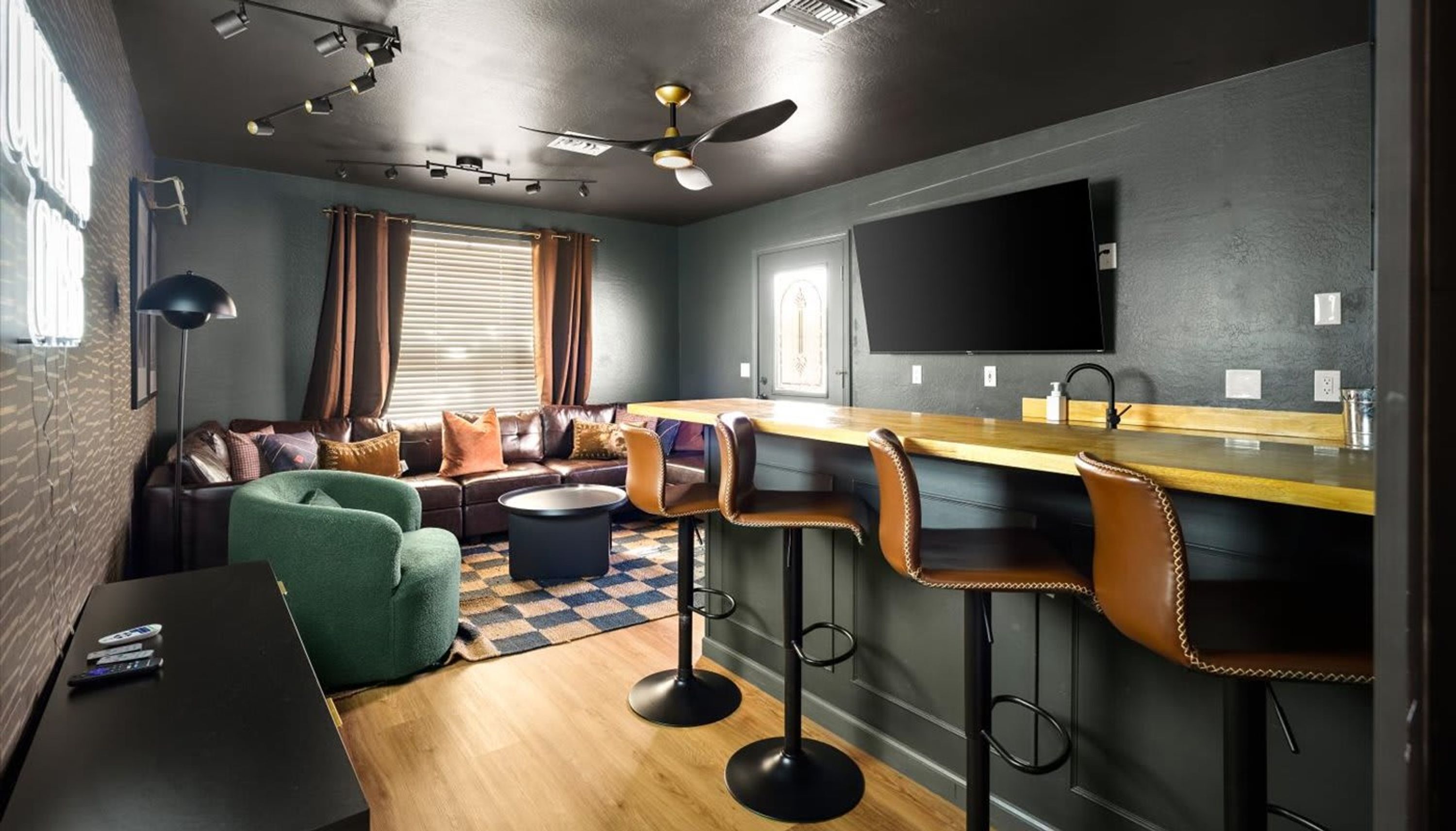 Ett modernt vardagsrum med en soffa, ett soffbord och en tv som är monterad på väggen.