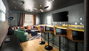 Ein modernes Wohnzimmer mit einer Couch, einem Couchtisch und einem an der Wand montierten Fernseher.