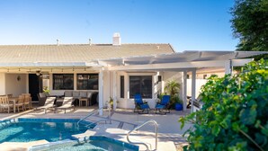 A pool area with lounge chairs, a pergola, and a covered patio. - Pool Spa Outdoor Fireplace BBQ Pool Table (Goodyear)