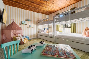A child's room with bunk beds, a play area with toys, and a striped wall. - Ocean Views Private Pool Walk to Beach (St. Augustine)