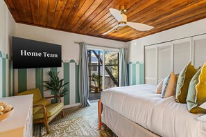 A bedroom with a bed, a chair, a television, and a ceiling fan. - Ocean Views Private Pool Walk to Beach (St. Augustine)