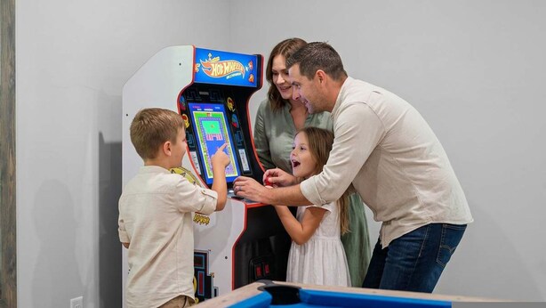 Una familia jugando un videojuego en una mesa con superficie azul.