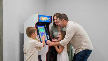 A family playing a video game at a table with a blue surface.