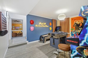 A room with a foosball table, a neon sign, and a Midway arcade machine. - Backyard Paradise - Pool - Tree House - Hot Tub (San Antonio)