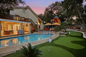 A residential property with a swimming pool, a covered patio, and a small golf course area. - Backyard Paradise - Pool - Tree House - Hot Tub (San Antonio)