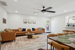 A modern living room with a sofa, coffee table, and dining area. - Casa Mesa Private Paradise w Pool Putt Games (Mesa)