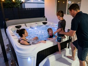 Ein Whirlpool mit einer Person und zwei Kindern darin.