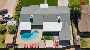 Ein Wohnhaus mit Swimmingpool, überdachter Terrasse und Garage.