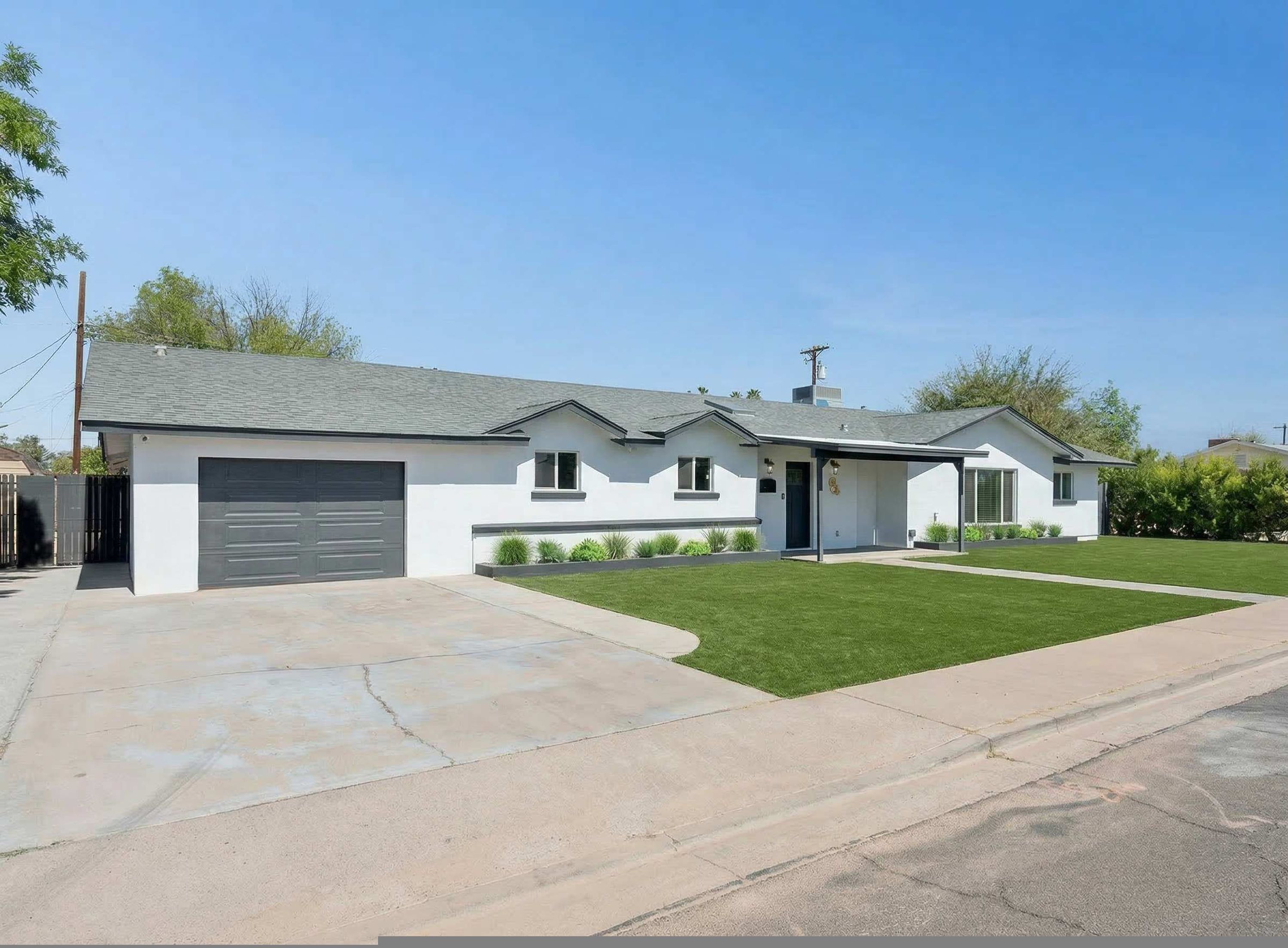 A single-story house with a garage, a covered porch, and a well-maintained lawn.