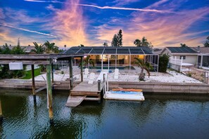 A waterfront property with a pool, a covered patio, and a dock with kayaks. - Private Dock Heated Pool Hot Tub Game Room Fun (Apollo Beach)