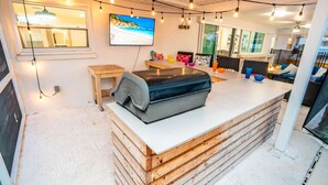 Een moderne keuken met een centraal eiland, houten kastjes en een groot raam.