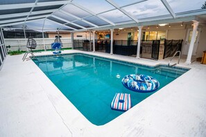 Ein Innenpool mit Glasdach, Liegestühlen und einer Poolbar.