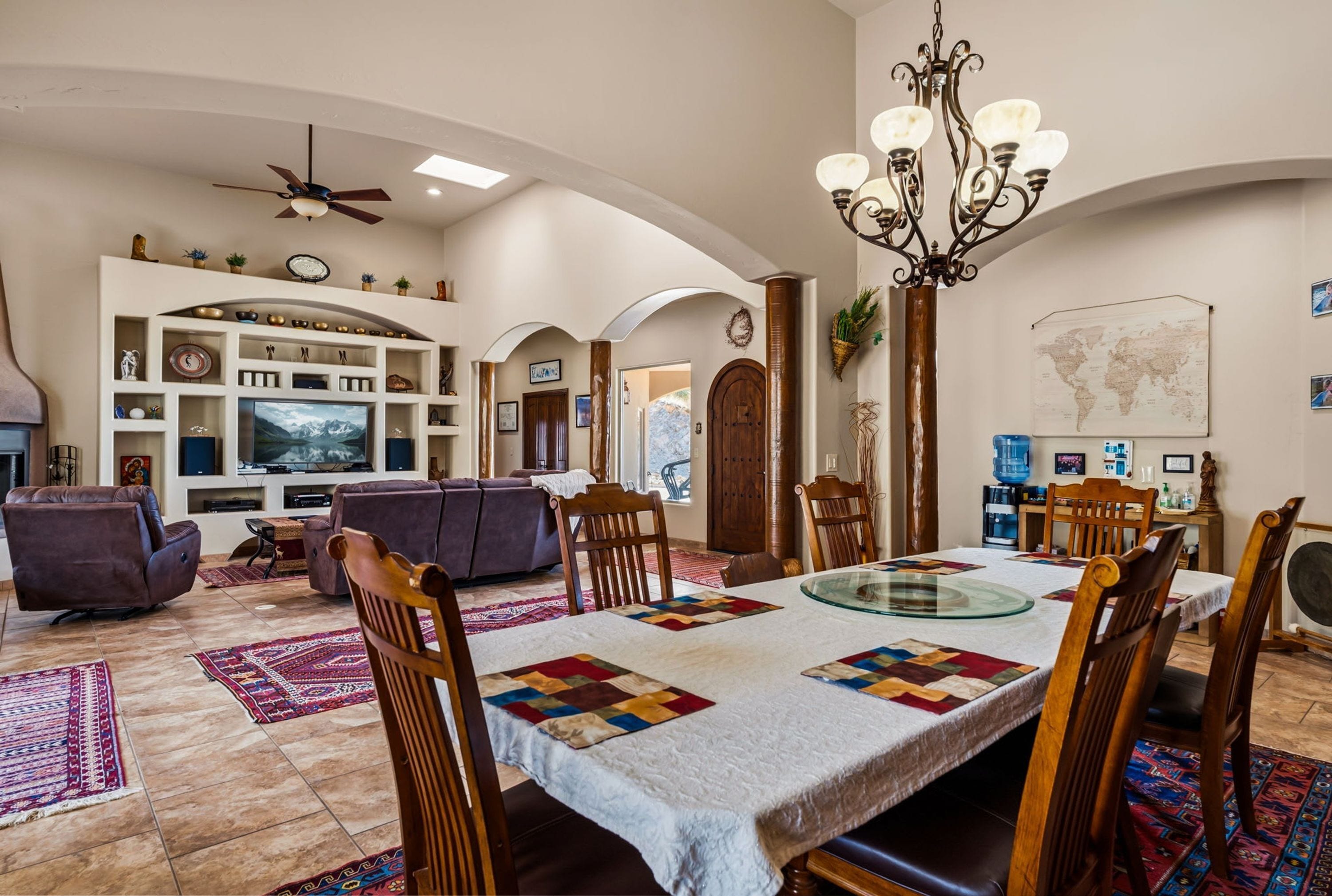 Un amplio salón con una mesa de comedor, sillas, un sofá y una televisión.