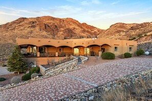 A modern building with a flat roof, multiple balconies, and a paved driveway leading to the entrance. - Private Estate Pool Views Events Welcome (Las Cruces)