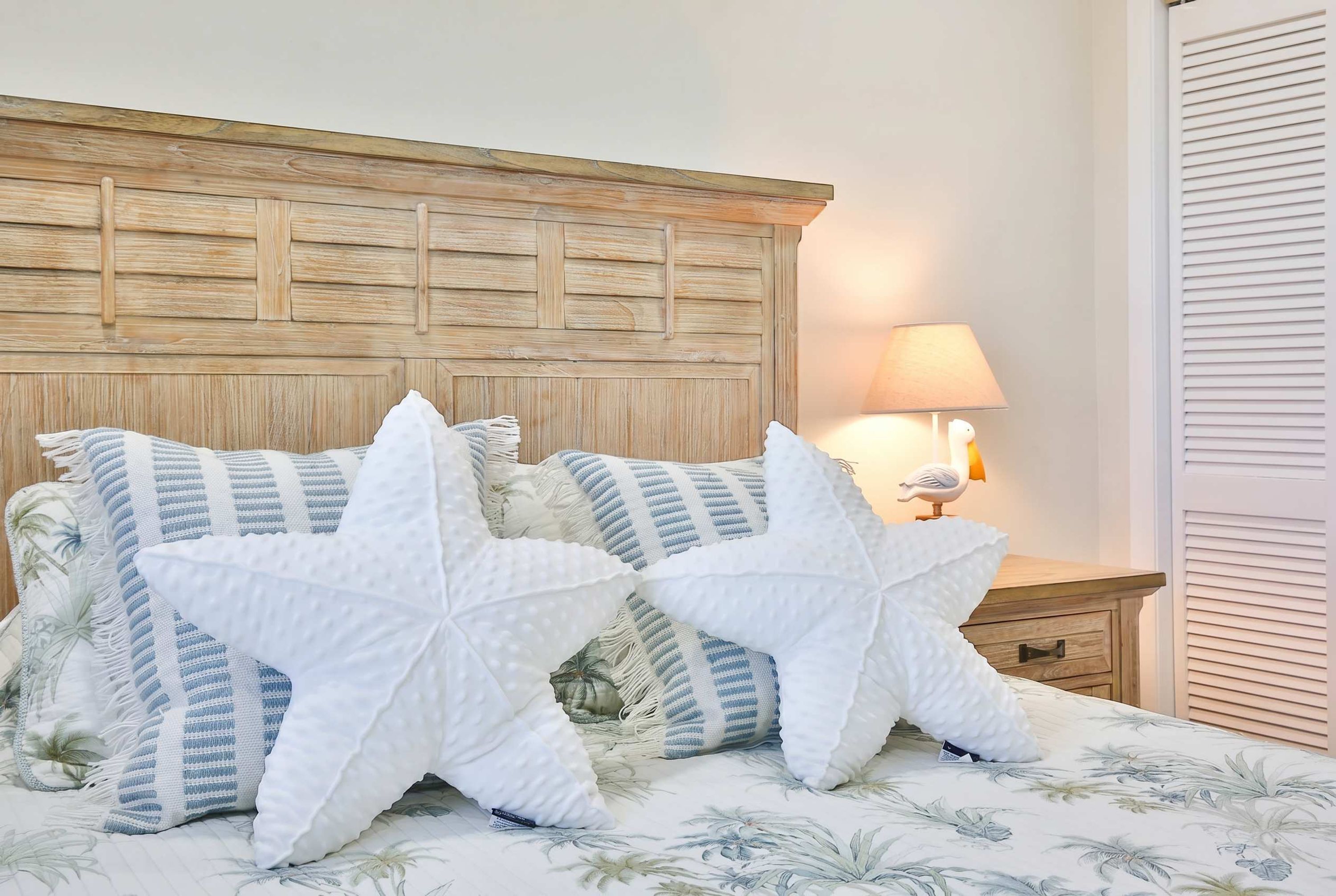 A bed with a wooden headboard, two large white pillows, and a floral-patterned bedspread.