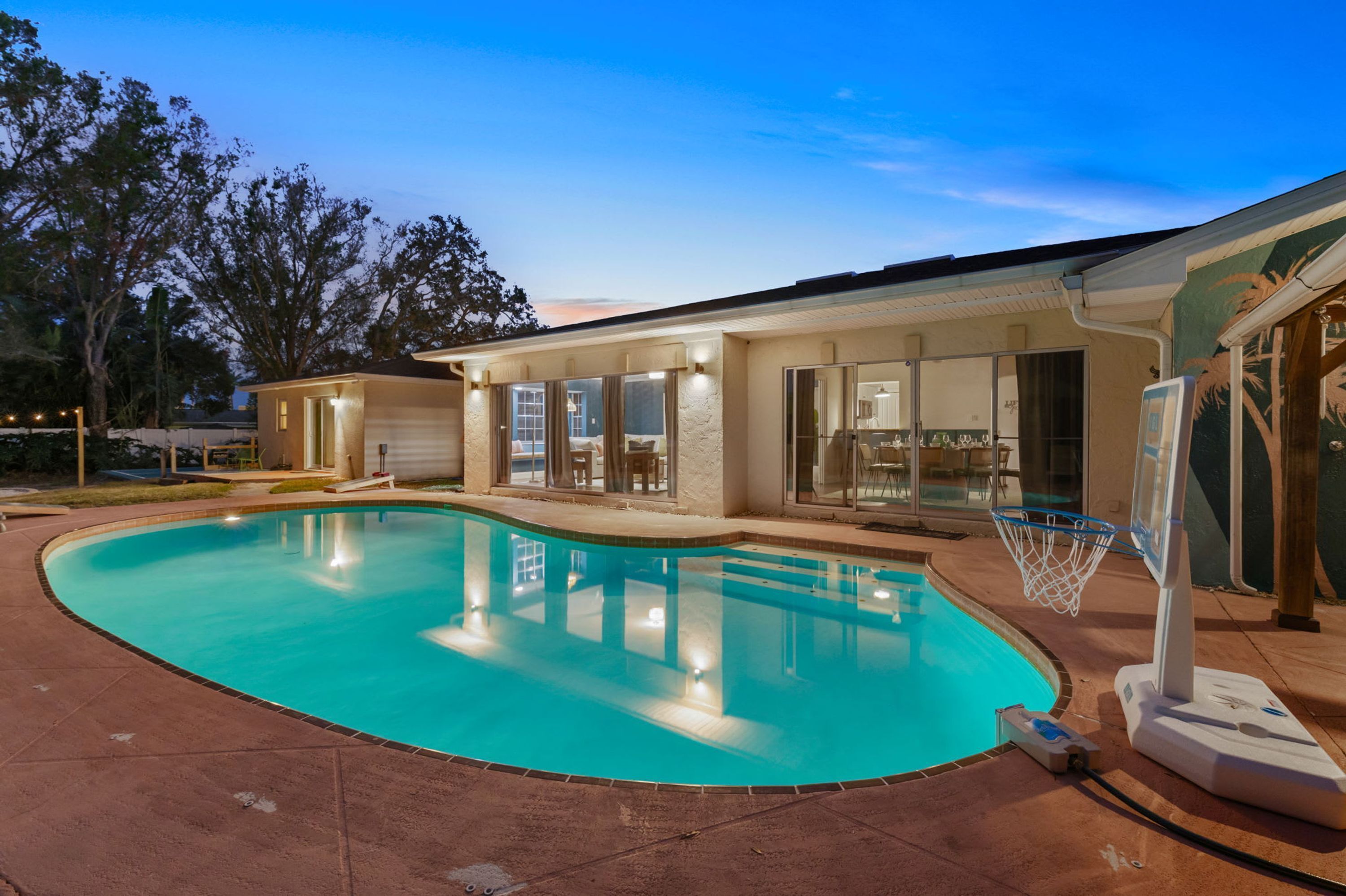 Ein Wohnhaus mit Swimmingpool, überdachter Terrasse und sichtbarer Garage.
