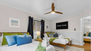 Ein Hotelzimmer mit zwei Betten, einem Deckenventilator, einem Fernseher und Blick ins Freie.