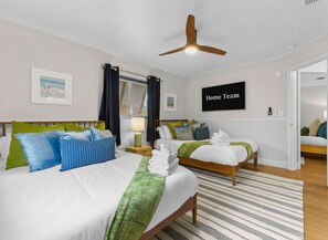 A hotel room with two beds, a ceiling fan, a TV, and a view of the outside. - Sleeps 20 Heated Pool Pickleball Hot Tub Fire Pit (Largo)