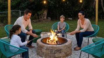Una familia reunida alrededor de un brasero con luces colgantes.