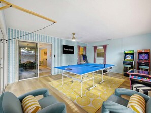 A room with a ping pong table, arcade games, and a sign that reads 'Home Team'. - Bradenton Vacation Haven Pool Hot Tub Arcade (Bradenton)