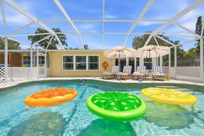 Ein Poolbereich mit Luftmatratzen, Liegestühlen und Sonnenschirmen.