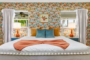 A bedroom with a bed, pillows, a blanket, two bedside lamps, a ceiling fan, and a window with curtains. - Bradenton Vacation Haven Pool Hot Tub Arcade (Bradenton)