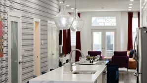 A modern kitchen with a marble countertop, a stainless steel sink, and pendant lights. - Victory Lane Villa Game Room - Hot Tub - Firepit (Indianapolis)