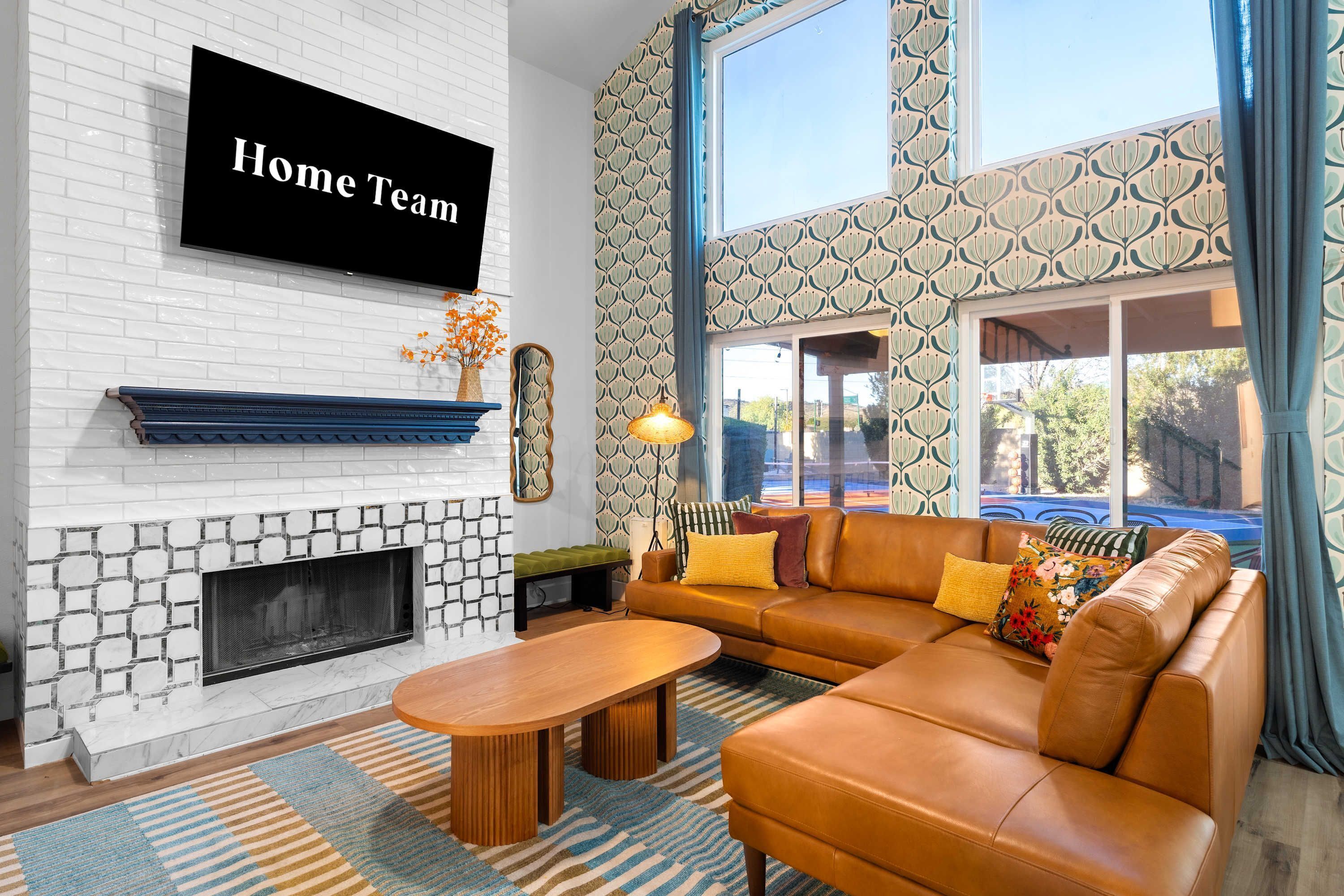 A modern living room with a fireplace, a sofa, a coffee table, and a television mounted on the wall.