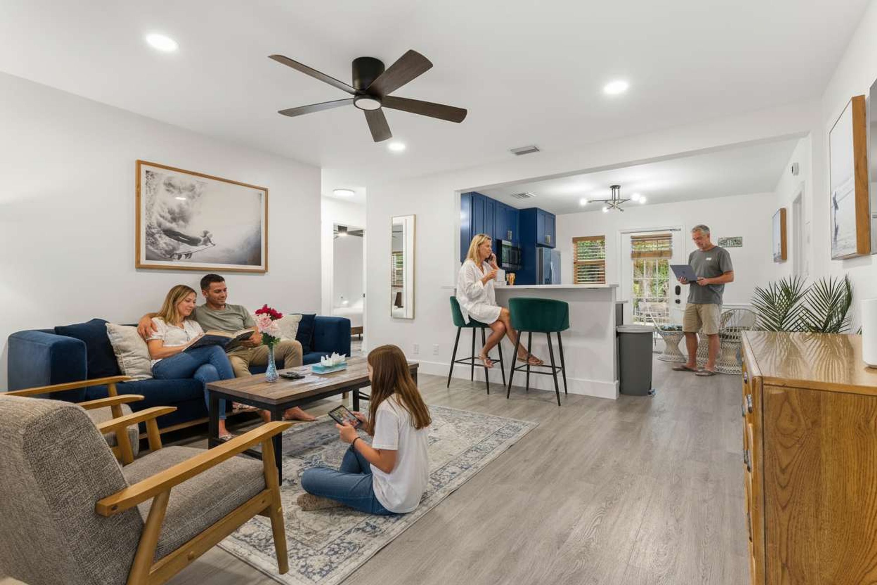 A modern living room with a sofa, chairs, a coffee table, and a dining area with a bar.