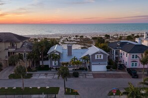 A residential area with houses, a stop sign, and a view of the beach at sunset. - Award-winning Private Beach Breathtaking Sunsets (Clearwater Beach)