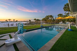 A swimming pool with a view of the beach and palm trees. - Award-winning Private Beach Breathtaking Sunsets (Clearwater Beach)