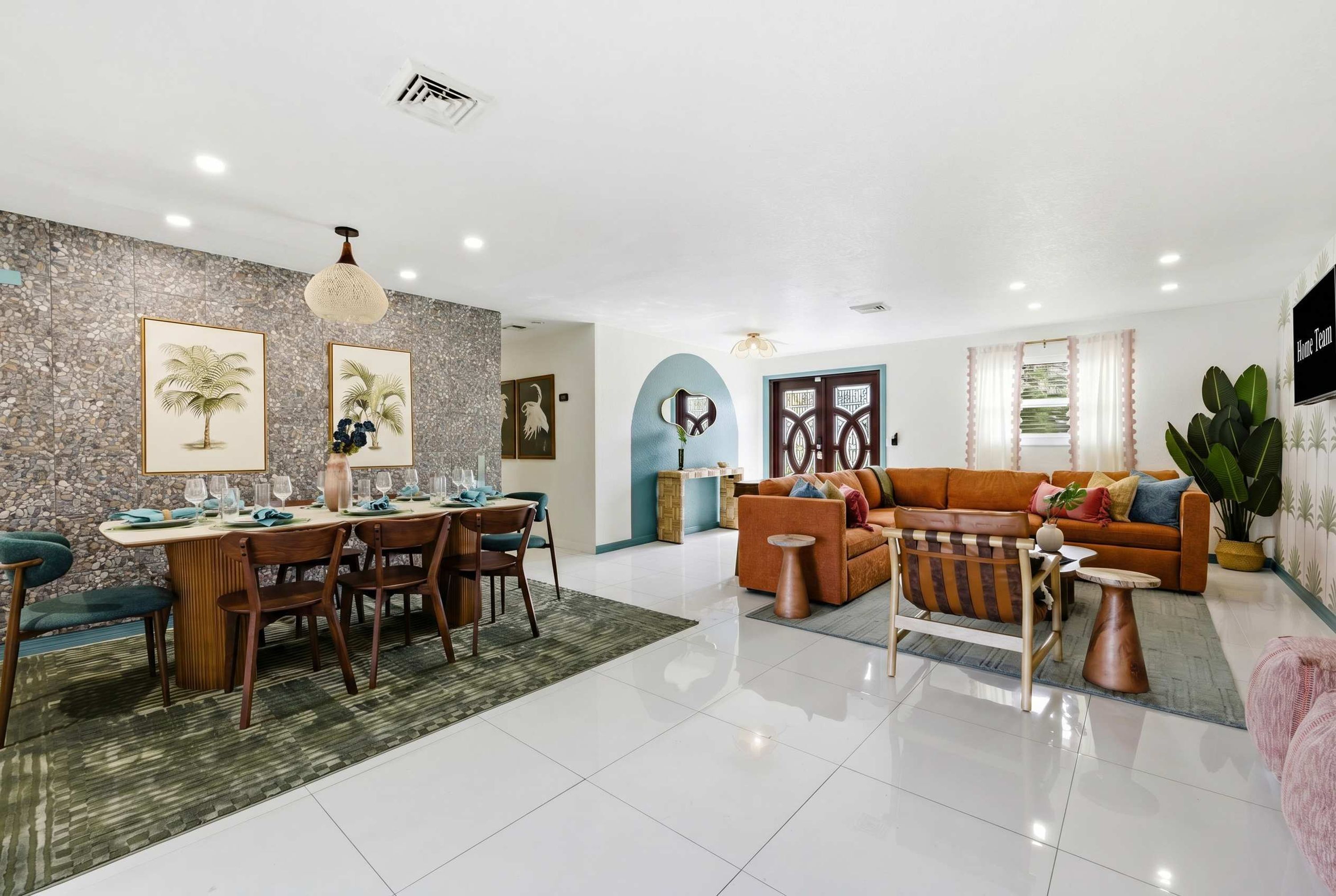 A spacious living area with a dining table set for four, a sofa, and a coffee table.