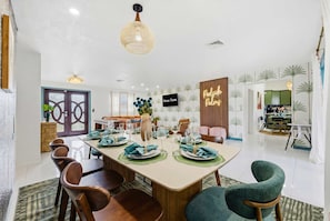 Comedor con una mesa larga dispuesta para seis personas, rodeada de sillas de madera.