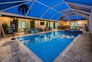 Una piscina interior con zona cubierta, asientos y bar.
