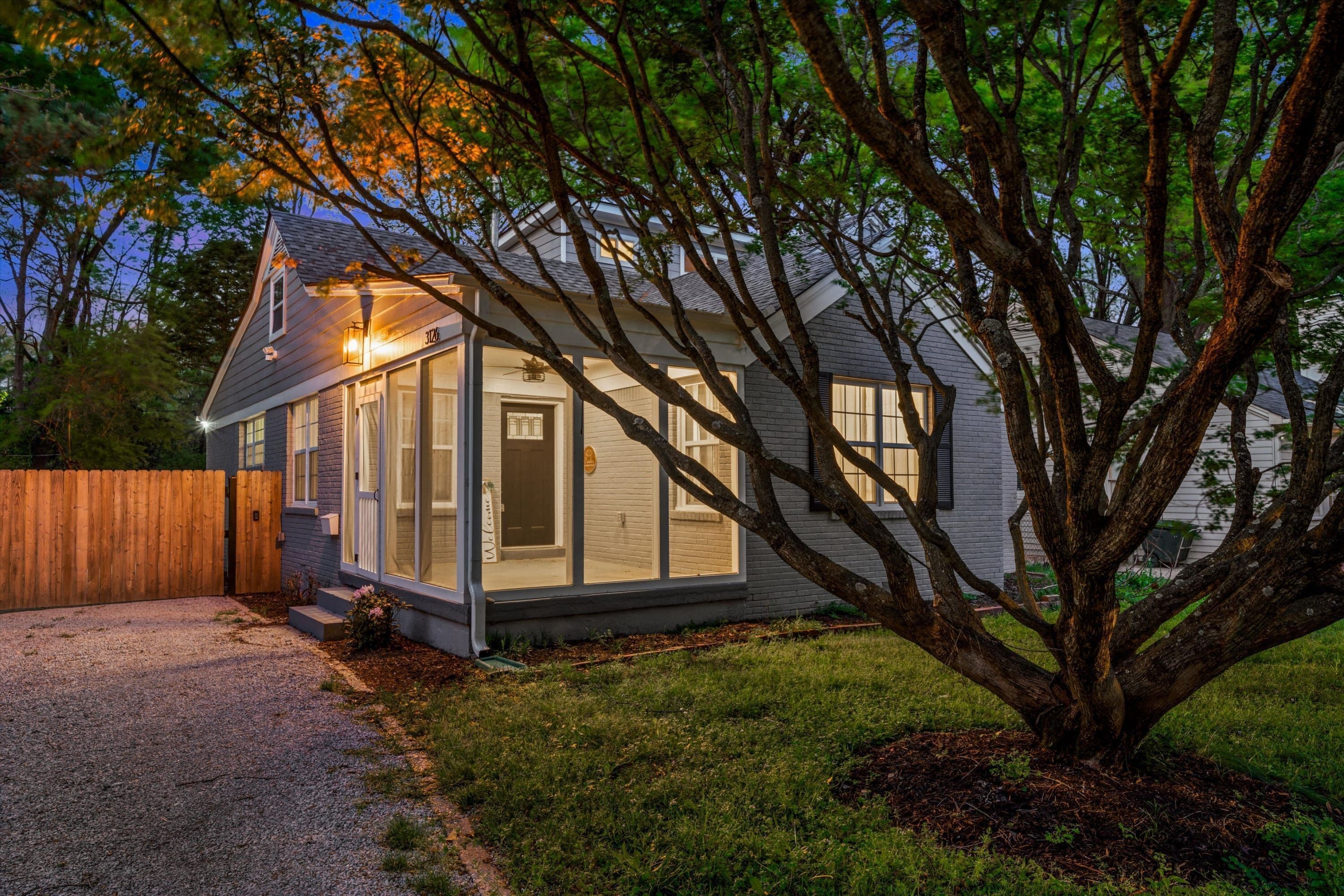 A single-story house with a sloped roof, large windows, and a visible door.