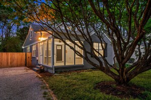 A single-story house with a sloped roof, large windows, and a visible door. - 5BR Hot tub Pool Table Mins to Beale (Memphis)