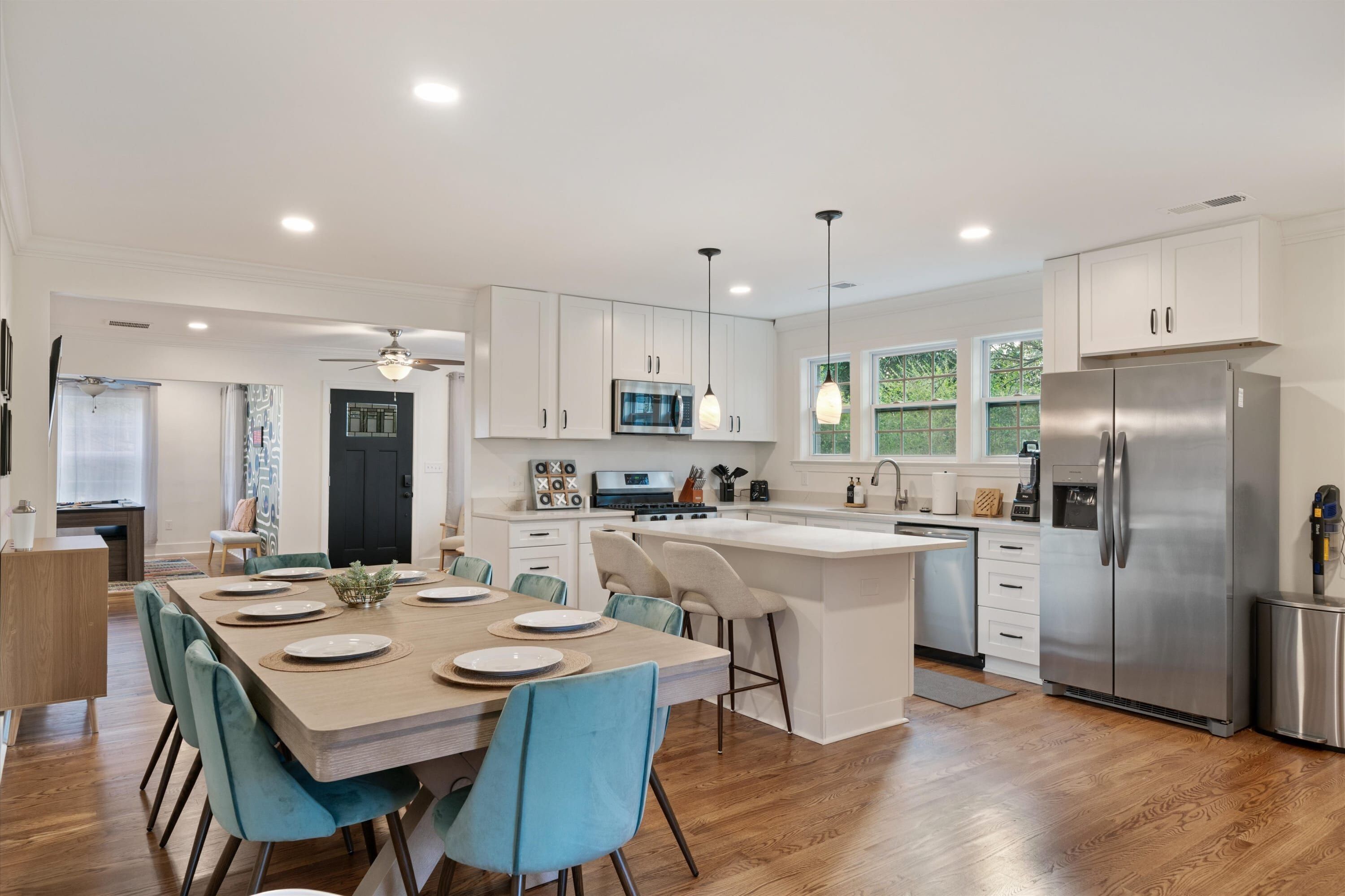 A modern kitchen with white cabinets, stainless steel appliances, and a central island with seating.