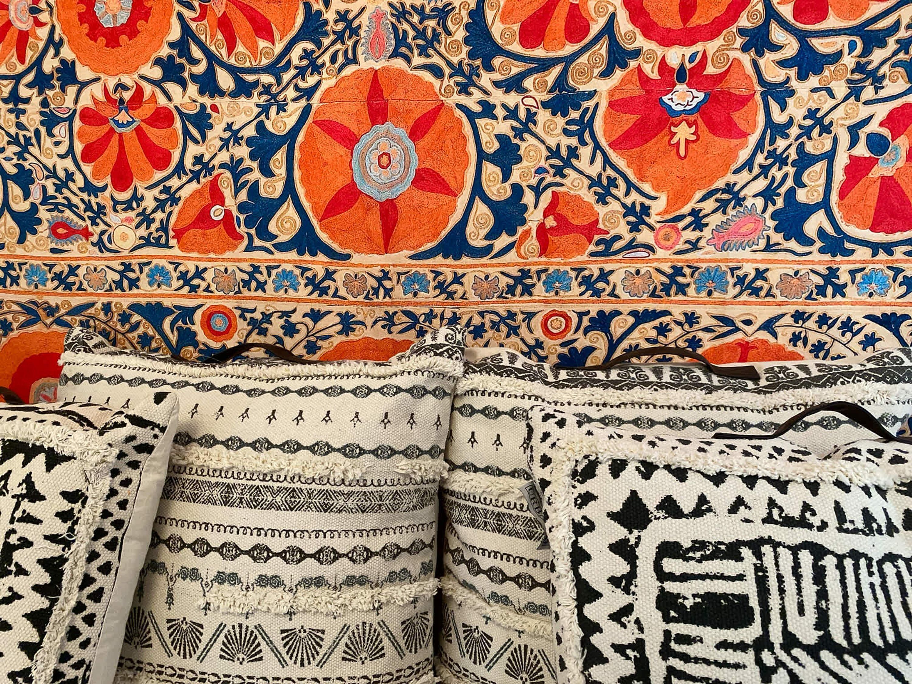 A collection of intricately patterned textiles, likely used for upholstery or decoration.