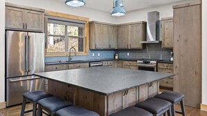 A modern kitchen with a central island, stainless steel appliances, and wooden cabinetry. - Mountain View Hot Tub Sauna Fire Pit (Blue Ridge)